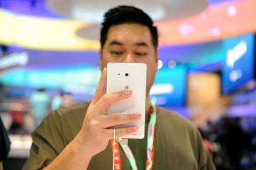 A visitor tries out a Huawei Ascend Mate ''phablet'' at the 2013 International CES in Las Vegas, on January 9, 2013