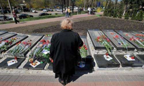 A woman looks at the signs with names of victims during a Chernobyl commemoration ceremony, Kiev on April 26, 2013.