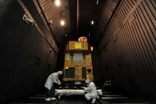 Brazilian researchers work inside a reinforced chamber on a CBERS satellite (China-Brazil Earth Resources Satellite), at Nationa