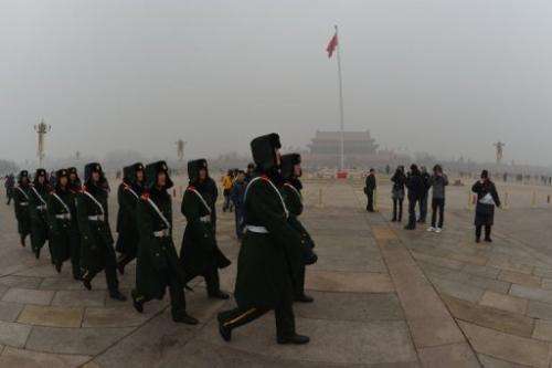 Chinese military policemen march through Tiananmen Square during heavy air pollution in Beijing on January 30, 2013