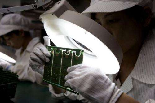 Chinese workers make mobile handsets at a factory in Shenzhen on December 19, 2008