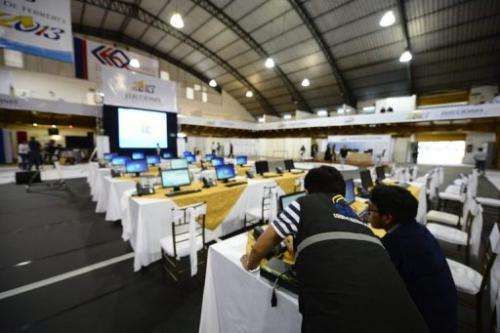 Members of the National Election Council check final details on the eve of general elections in Quito, February 16, 2013