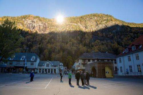 People gather on a spot in front of the town hall of Rjukan, Norway, on October 18, 2013