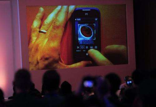 People look at a screen displaying a ZTE mobile phone with a Firefox logo in Barcelona on February 24, 2013