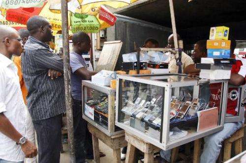 People queue outside a mobile phone stand in Lagos, on August 18, 2008