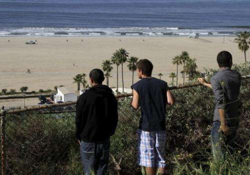 People watch a beach in Santa Monica on March 11, 2011, after tsunami warnings were issued along the US west coast