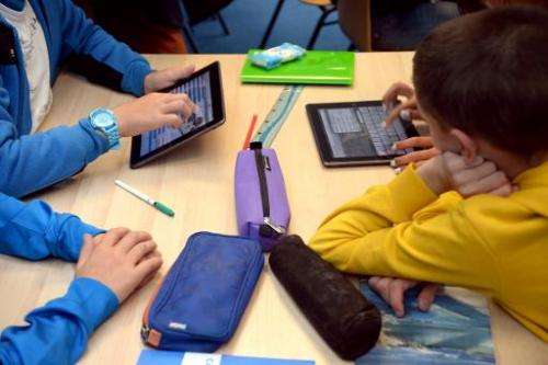 Pupils use tablets during courses in a classroom at a school in Saint-Brieuc, western France on September 12, 2013
