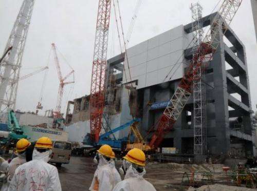 Reporters and Tokyo Electric Power Co workers look around during a media tour at the Fukushima plant on June 12, 2013