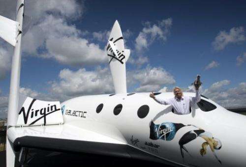 Richard Branson poses in the window of a replica of the Virgin Galactic spaceship in England on July 11, 2012