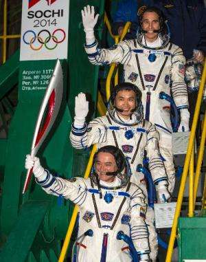This NASA photo shows Expedition 38 Soyuz Commander Mikhail Tyurin of Roscosmos, holding the Olympic torch, Flight Engineer Koic