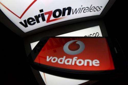 A picture taken on September 2, 2013 in Paris, shows the logo for Verizon Wireless and the logo of Vodafone