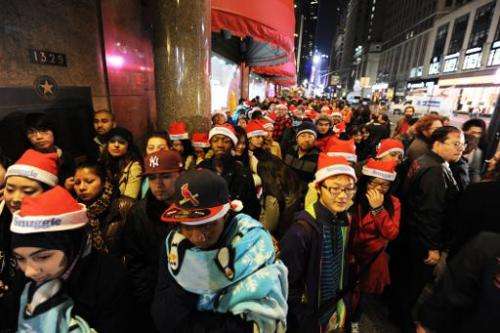 This file photo shows people standing in line outside Macy's department store in New York, awaiting the midnight opening to begi