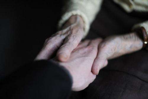 File photo shows a woman suffering from Alzheimer's holding the hand of a relative at a retirement home in France