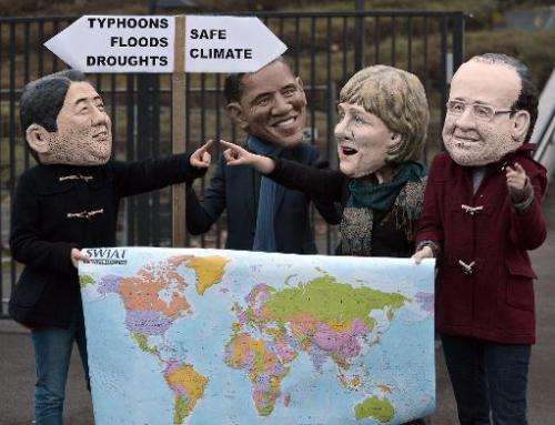 Activists wearing masks of French President Francois Hollande, German Chancellor Angela Merkel, US President Barack Obama and Ja