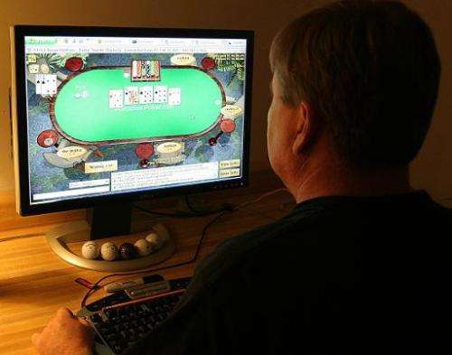 A man plays poker on his computer connected to an internet gaming site from his home in Manassas, Virginia on October 2, 2006