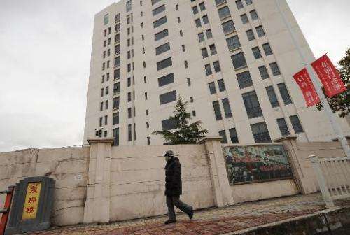 A person walks past a 12-storey building in Shanghai alleged in an Internet security firm Mandiant report in February 2013, to b