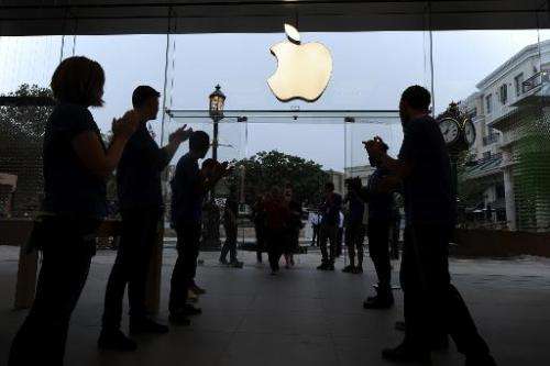 Apple employees applaud as they welcome the first shoppers arriving to purchase the new Apple iPhone 5S and 5C, at the Apple Sto
