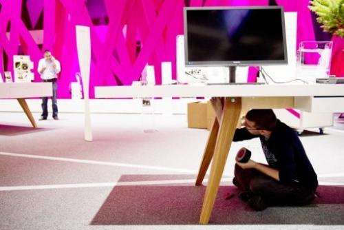A staff member works on the Deutsche Telekom at the IFA trade fair in Berlin on August 30, 2012