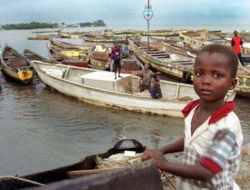 Children play on fishing boats in the harbour at Conakry, Guinea, on August 10, 1999