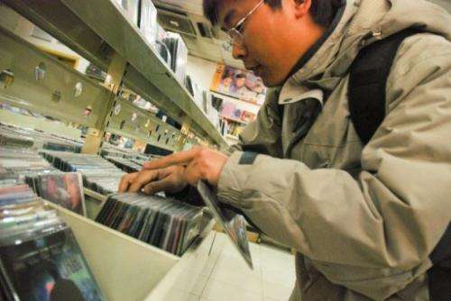 File picture shows a customer looking at pirated DVDs at a shop in Beijing.