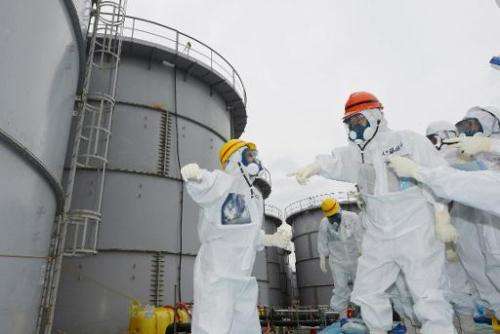 Fukushima Governor Yuhei sato (orange helmet) inspects the contaminated water tanks at Tokyo Electric Power Co (TEPCO) Fukushima