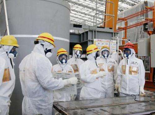 Japanese Prime Minister Shinzo Abe (right) is briefed by Fukushima Dai-ichi nuclear power plant chief Akiro Ono (third right) du
