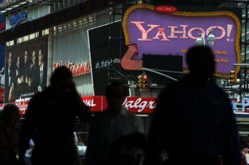 Pedestrians walk by a Yahoo! sign in Times Square on July 29, 2009 in New York City