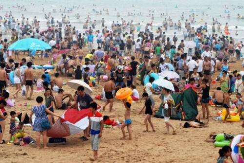 People cool off on a beach in Qingdao, in eastern China, August 11, 2013