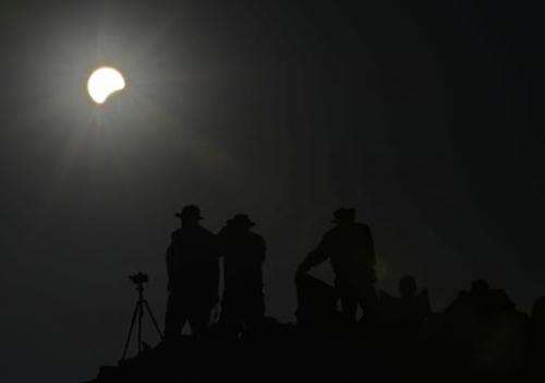 People watch as the moon appears to cover the sun on May 20, 2012 from the Pueblo Bonito ancient building at Chaco Culture Natio