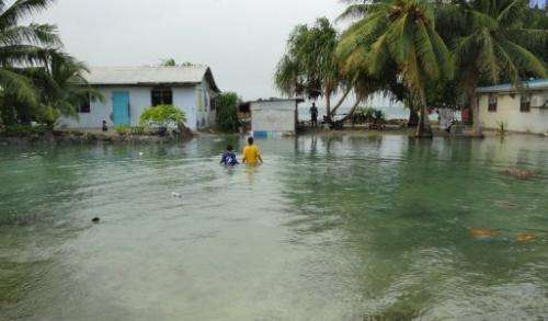 Residents wade through flooding caused by high ocean tides in low-lying parts of Majuro Atoll, Marshall Islandsin 2011