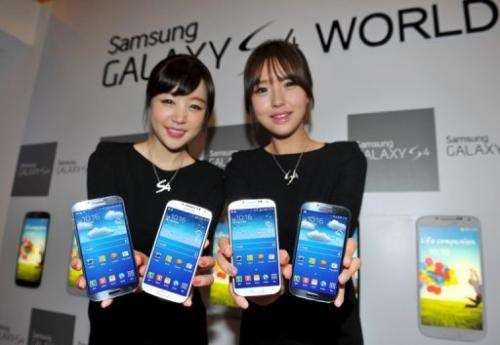 Samsung Electronics employees display the  Galaxy S4 smartphone in Seoul on April 25, 2013