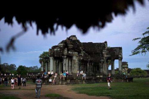 Tourists visit Angkor Wat temple during sunrise in Siem Reap, Cambodia, on July 14, 2012