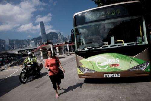 A woman walks past an electric bus in Hong Kong on September 9, 2013