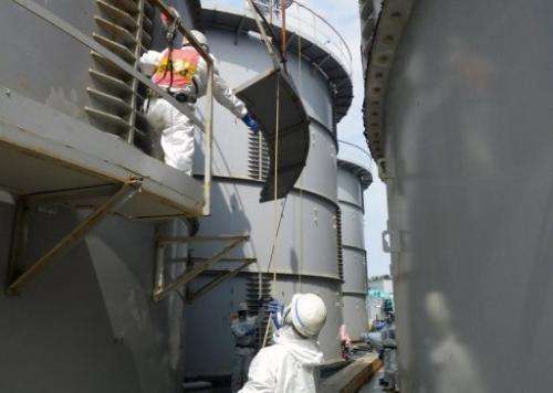Image taken by TEPCO on September 13, 2013 shows workers taking apart a contamination water tank at the Fukushima plant