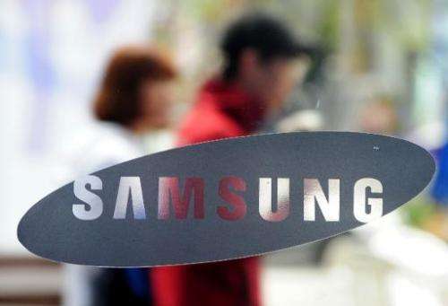 South Koreans walk past a Samsung logo in Seoul on April 22, 2011