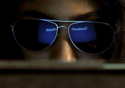 The 'Facebook' logo is reflected in a young woman's sunglasses as she browses the Internet in Bangalore, on May 15, 2012