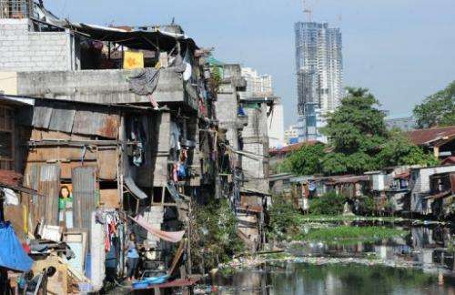 This picture taken on February 18, 2013 shows informal settlers' homes along a polluted waterway in Manila