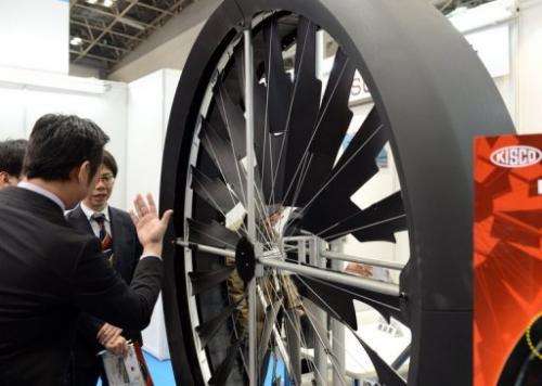 Visitors look at KISCO's Tam Turbine wind power generator during the PV Expo in Tokyo, on February 27, 2013