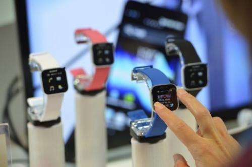 A woman tries out mobile phone and media player watches at the Sony booth at the IFA fair in Berlin on August 30, 2012