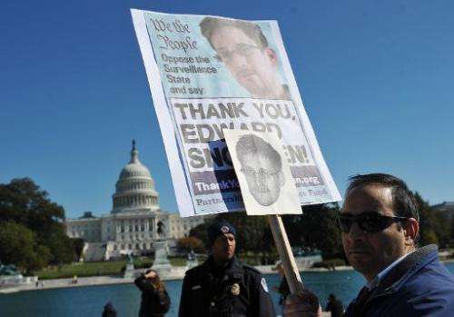 Demonstrators hold placards supporting former US intelligence analyst Edward Snowden during a protest against government surveil