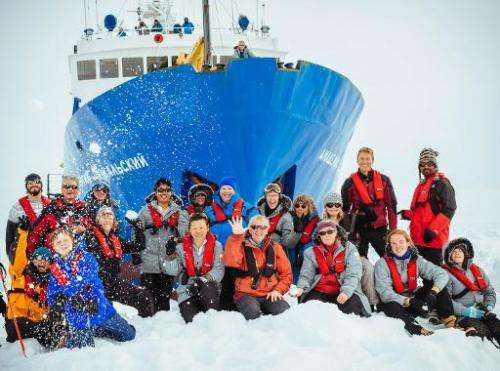 Image taken by Andrew Peacock on December 28, 2013 shows passengers posing for a photo with the MV Akademik Shokalskiy, which is