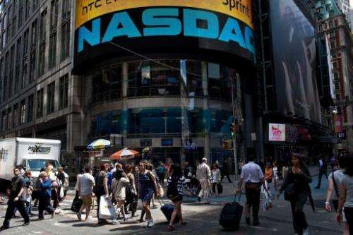 People walk past the Nasdaq exchange in Time Square on June 7, 2012 in New York City