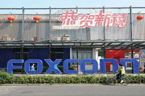 People walk past a Foxconn recruitment point in Shenzhen, south China's Guangdong province, on February 22, 2013