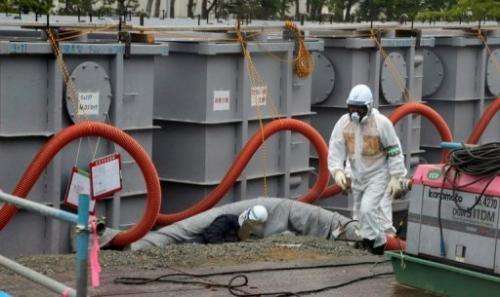 File picture shows a TEPCO worker next  to waste water tanks at Fukushima Daiichi nuclear plant on June 12, 2013