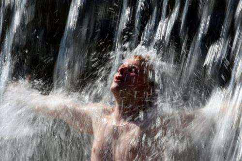 A Belarus man cools down in a fountain during a hot summer day in Minsk on July 11, 2010