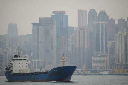 A boat enters the Victoria Harbour on January 10, 2013 as a haze of pollution shrouds the Hong Kong's skyline