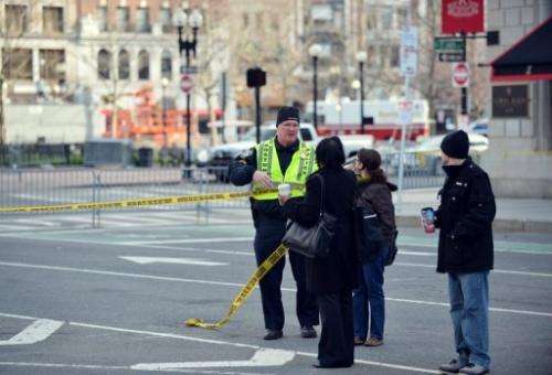 A Boston police officer speaks to passersby outside the Fairmont Copley Plaza Hotel on April 16, 2013 in Boston
