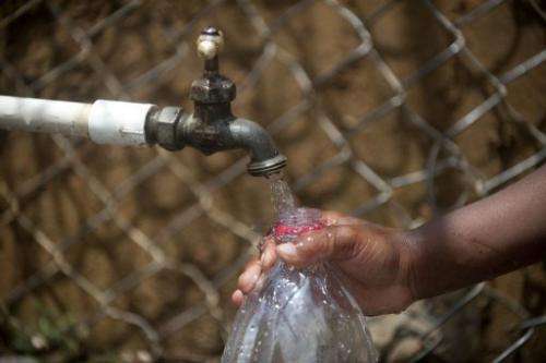 A child fills a bottle with water from a public tap in Colombia on March 22, 2013
