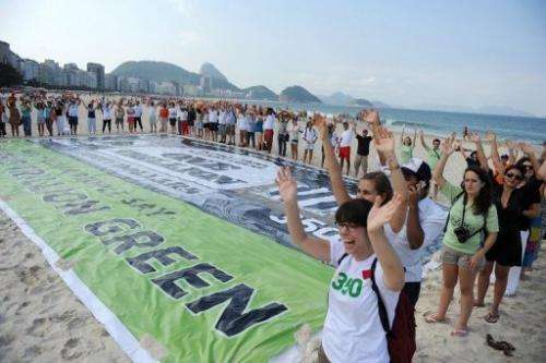 Activists from 350.org and other groups unveil a banner on Copacabana beach in Rio de Janeiro, Brazil on June 17, 2012