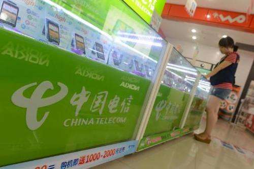 A customer selects mobile phones at a China Telecom store in Wuhan, in central China's Hubei province on August 21, 2013
